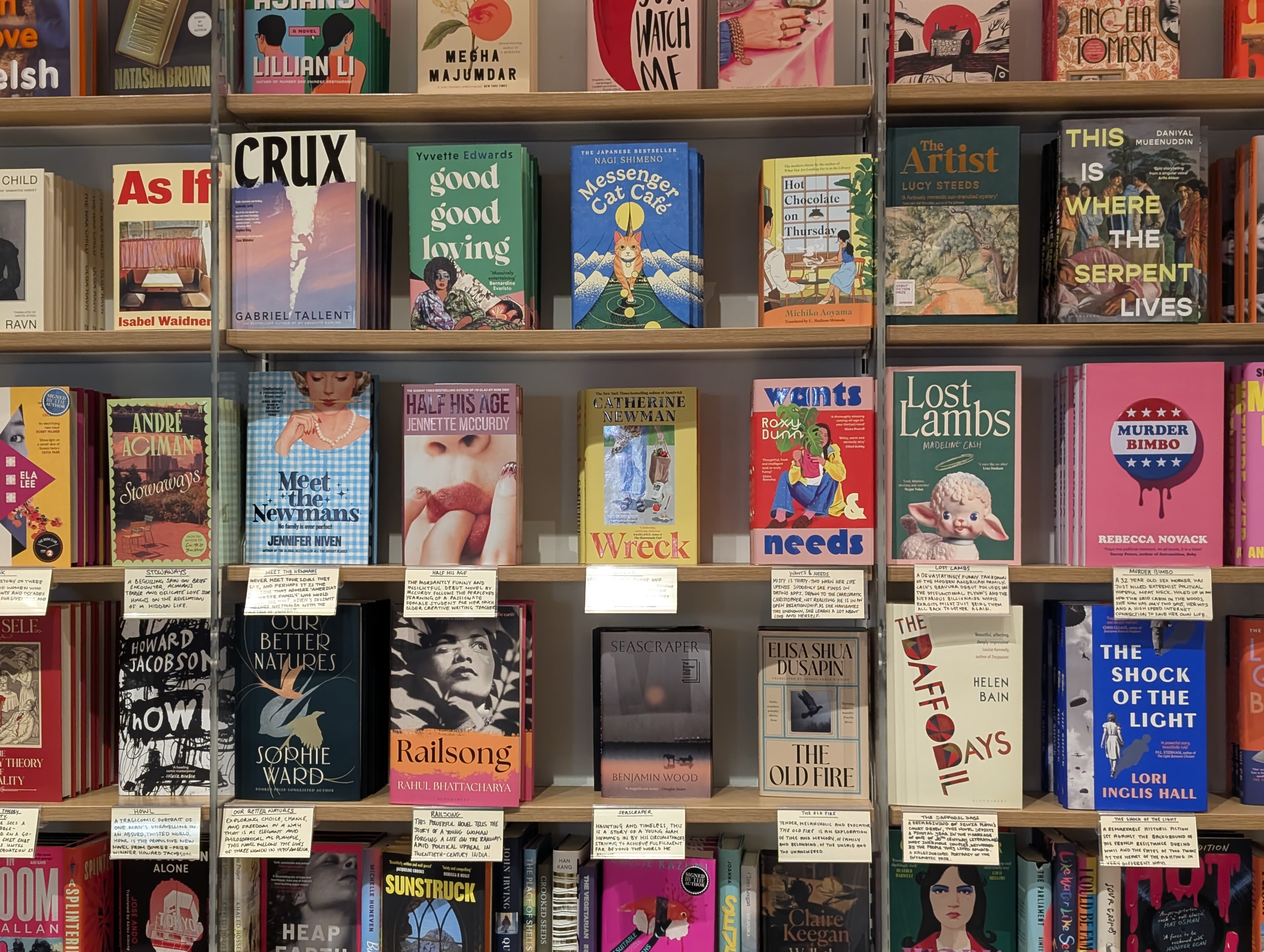 A busy wall of colourful books in a bookshop