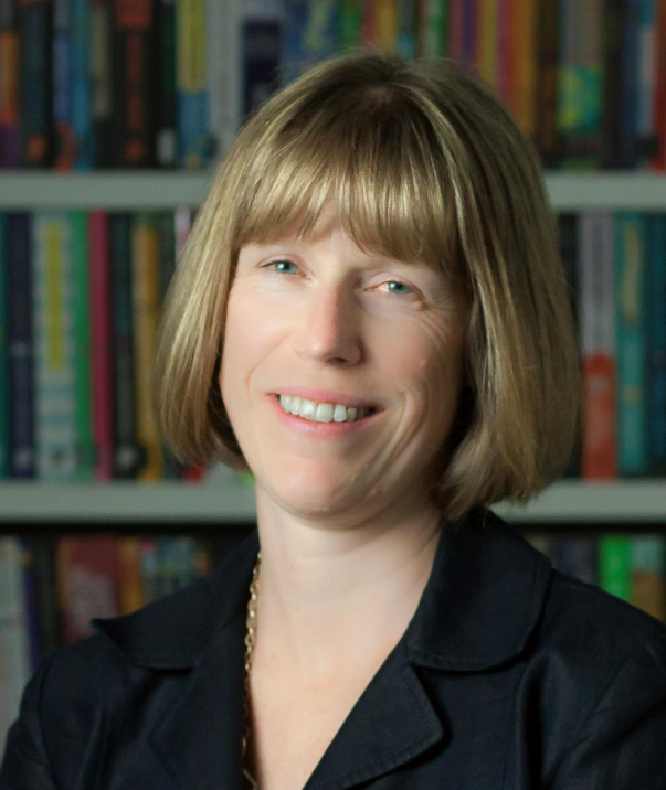 Tracy Phillips smiles at the camera with books behind her