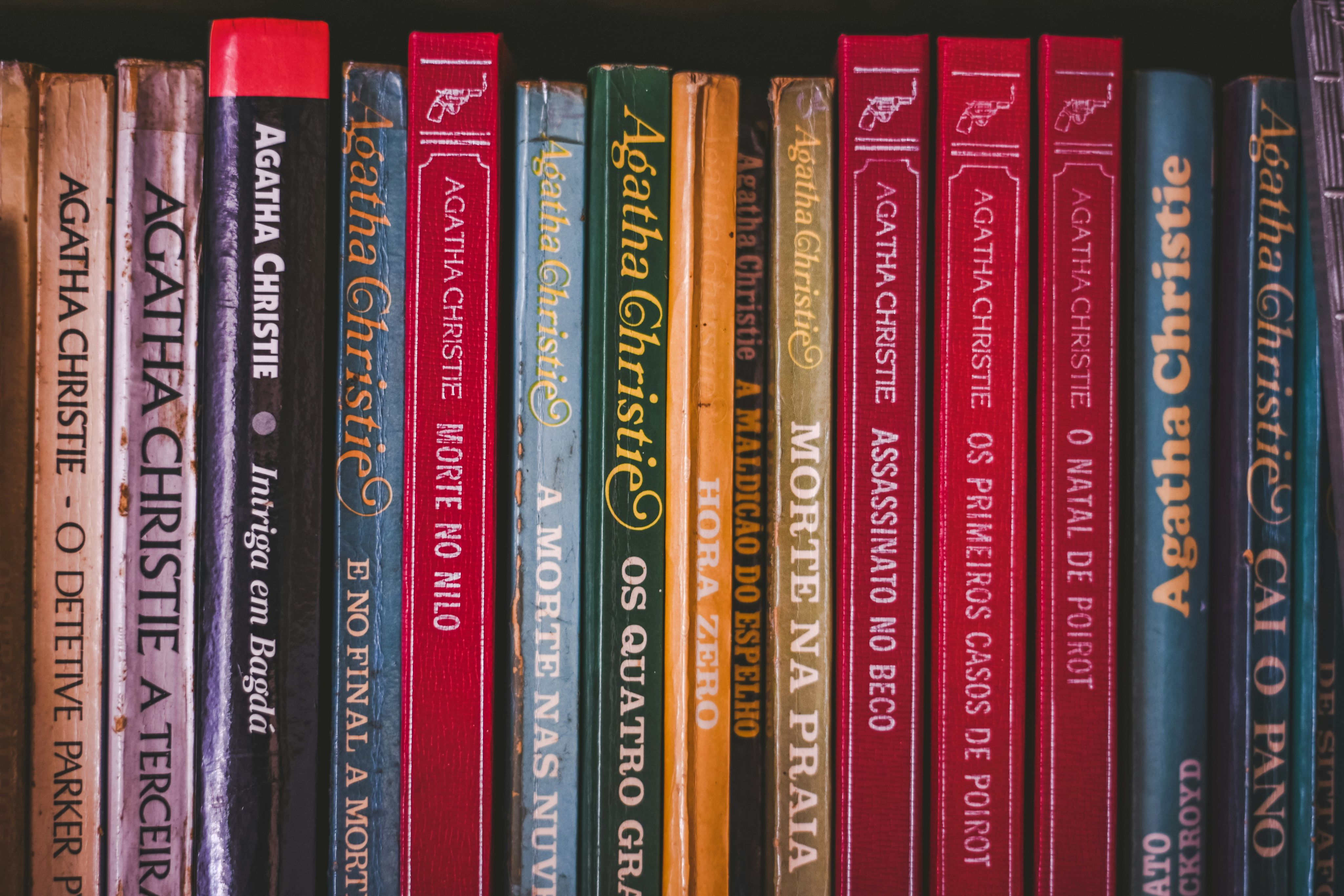 a row of books sitting on top of a book shelf