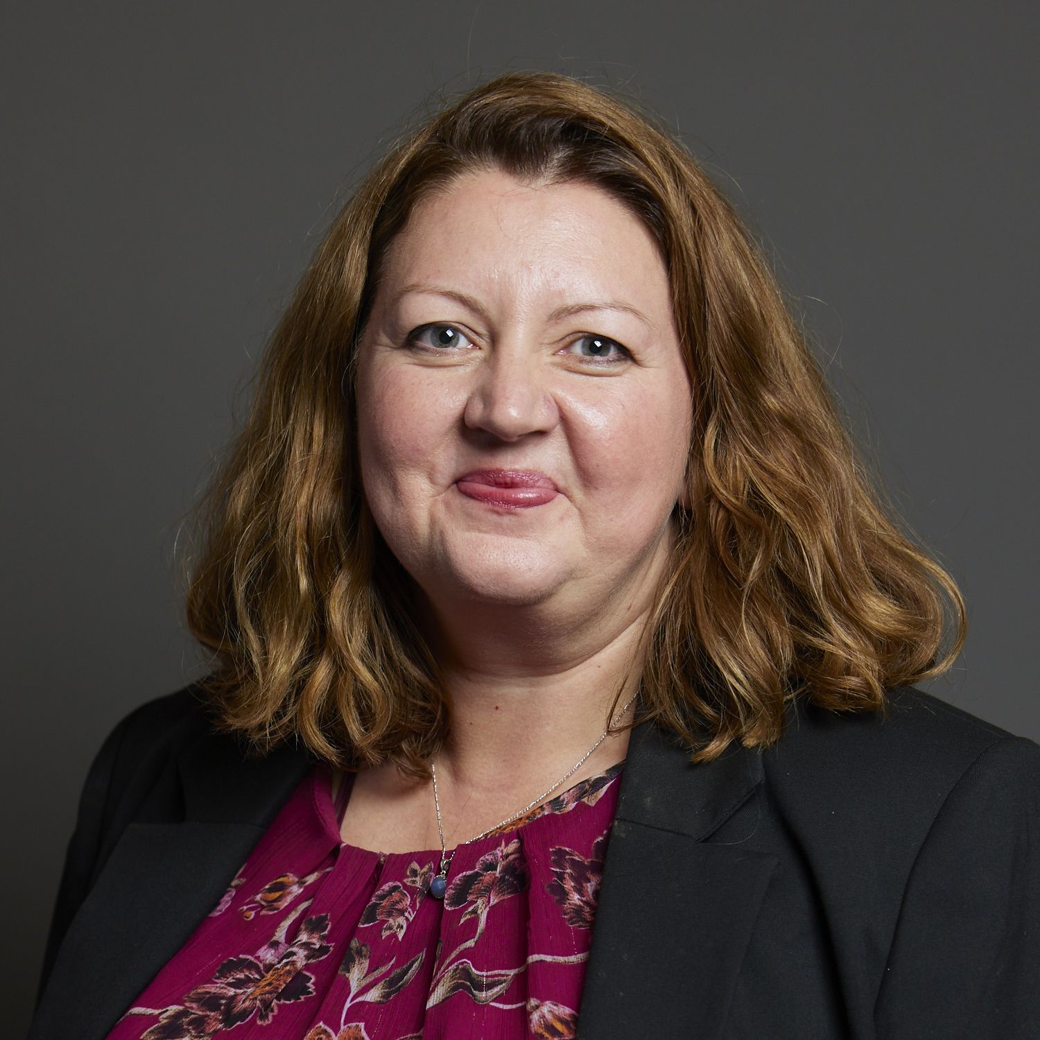 Kirsty McNeill wears a suit jacket and red print dress